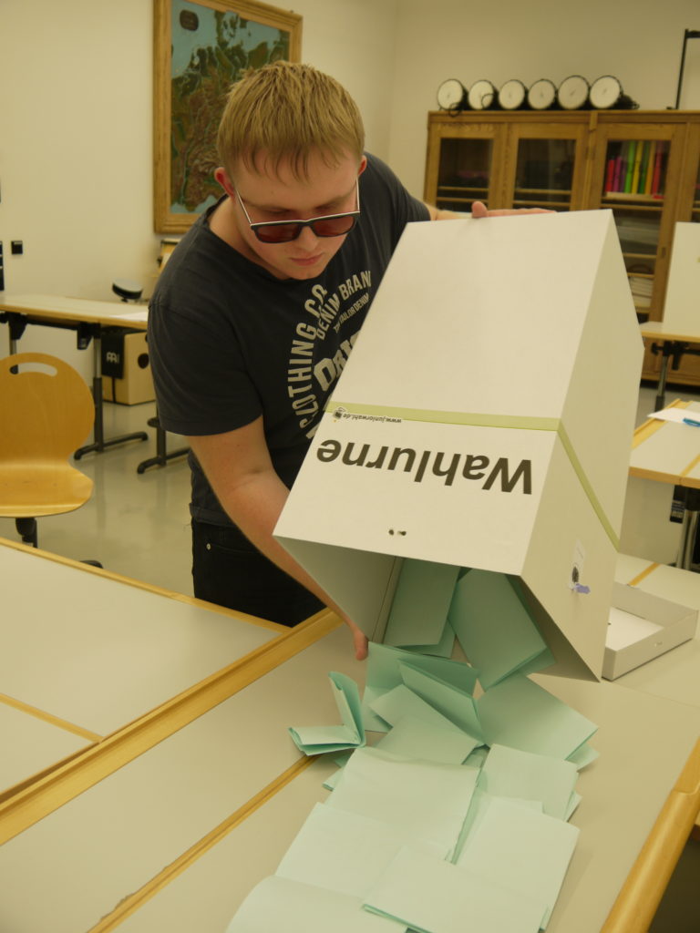 Schüler Danny schüttet die Wahlurne aus.