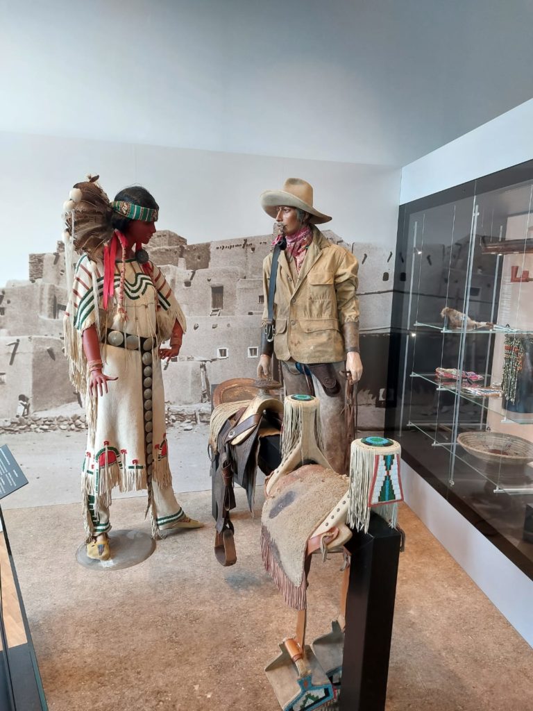 Lebensgroße Puppen von Winnetou und Old Shatterhand in historischen Kostümen. Vor den Figuren gibt es  Pferdesattel zu sehen.