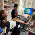 Schüler der AG Podcast sitzen um einen PC