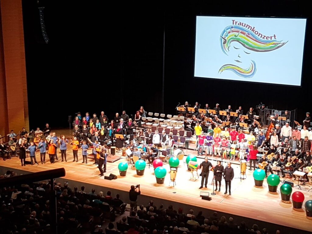 Auf der Bühne stehen und sitzen alle Musiker und ihre Instrumente