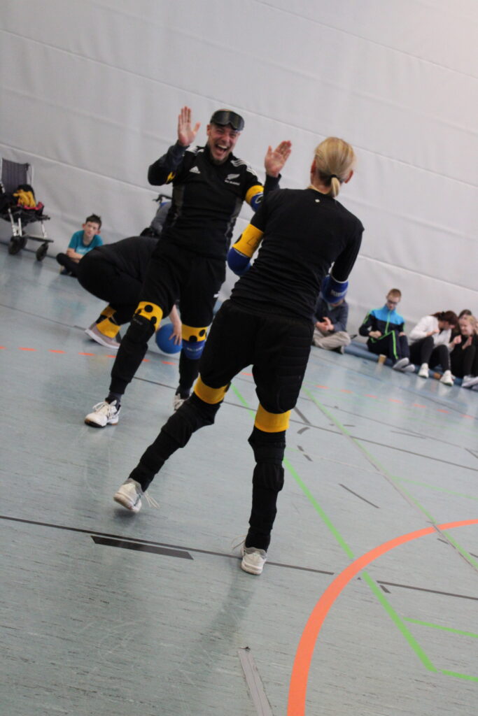 Spieler des Lehrerteams freuen sich und klatschen ab, weil das Spiel gewonnen wurde