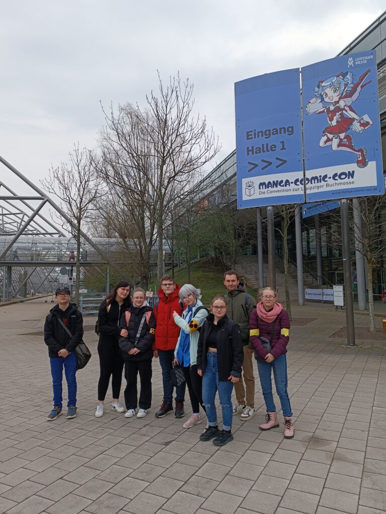 Gruppenfoto der Schülerinnen und Schüler vor dem Eingangsbereich der Buchmesse