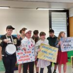 Gruppenfoto der Teilnehmenden, sie haben Plakate in der Hand: "Wir sind echte Freunde." "Gemeinsam sind wir stark." "Kinder haben Rechte".