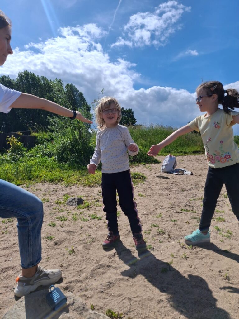 Schülerinnen und Lehrerin tanzen im Freien