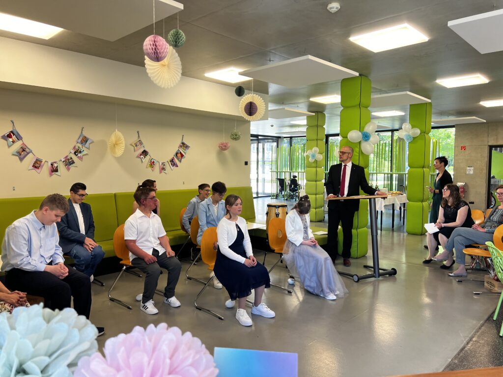Zur Feierstunde haben sich Herr Theiss und die "Erwachsenen" im Foyer von Haus 35 versammelt.