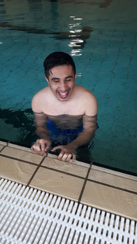 hier sehen wir einen Schüler im Wasser und lächelt