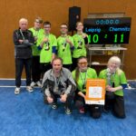 Siegerfoto mit allen 6 Spielern und den 2 Trainern. Auf der Anzeigetafel steht es 11:10 für Chemnitz. Eine Spielerin hat den Pokal in der Hand. Dazu tragen alle eine Medaille.