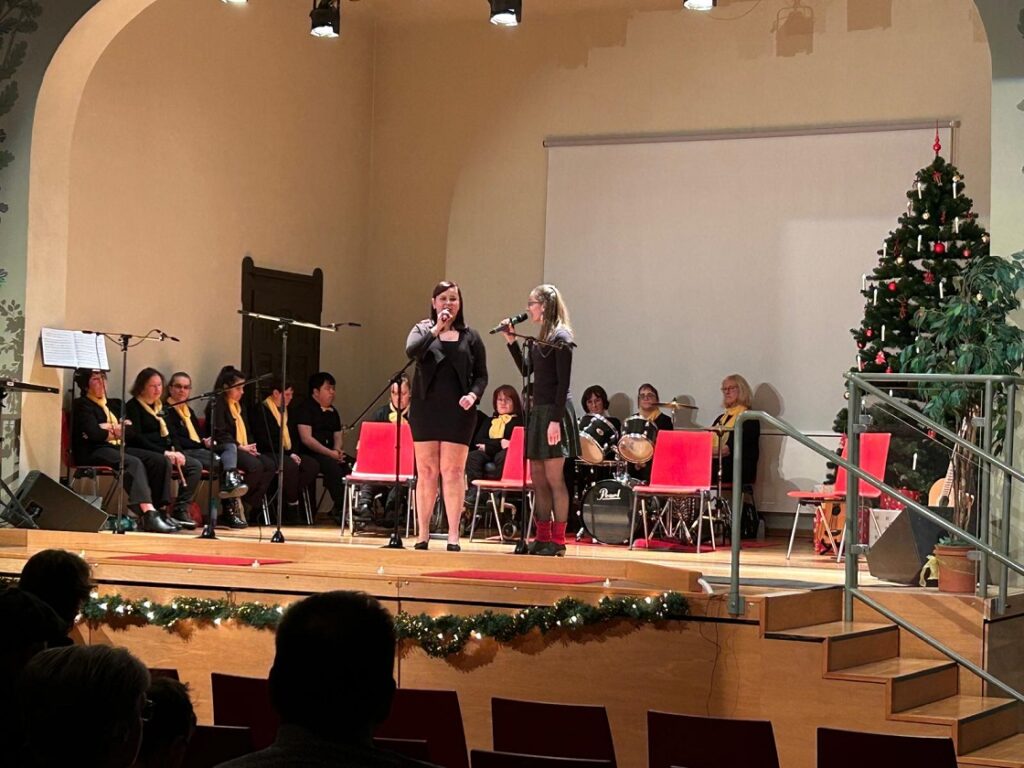 zwei lehrer die auf der Bühne stehen und singen
