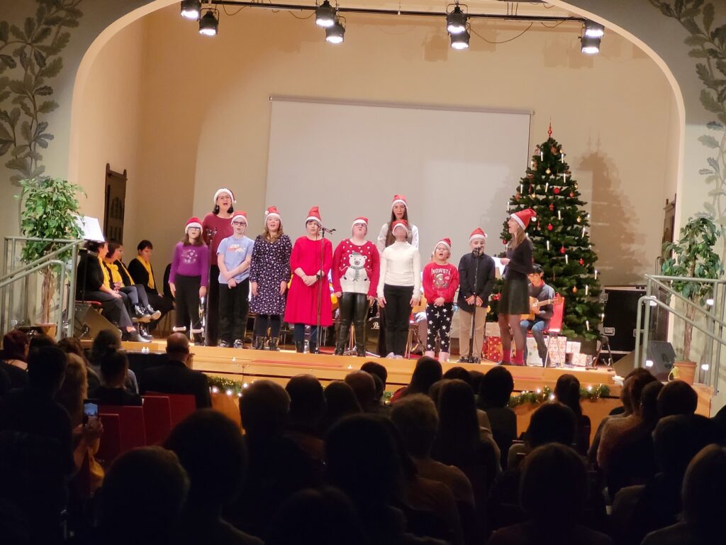 eine Gruppe die auf der Bühne stehen und singen