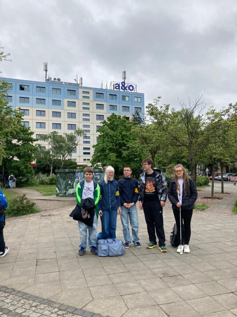 Die Reisegruppe vor dem Hotel, in dem sie untergebracht waren. Der Himmel ist bewölkt.