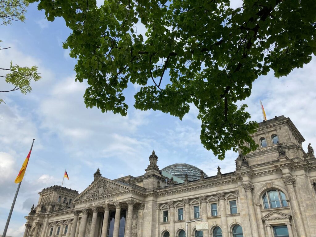 Das Reichstagsgebäude. Ein leicht bewölkter Himmel über Berlin.